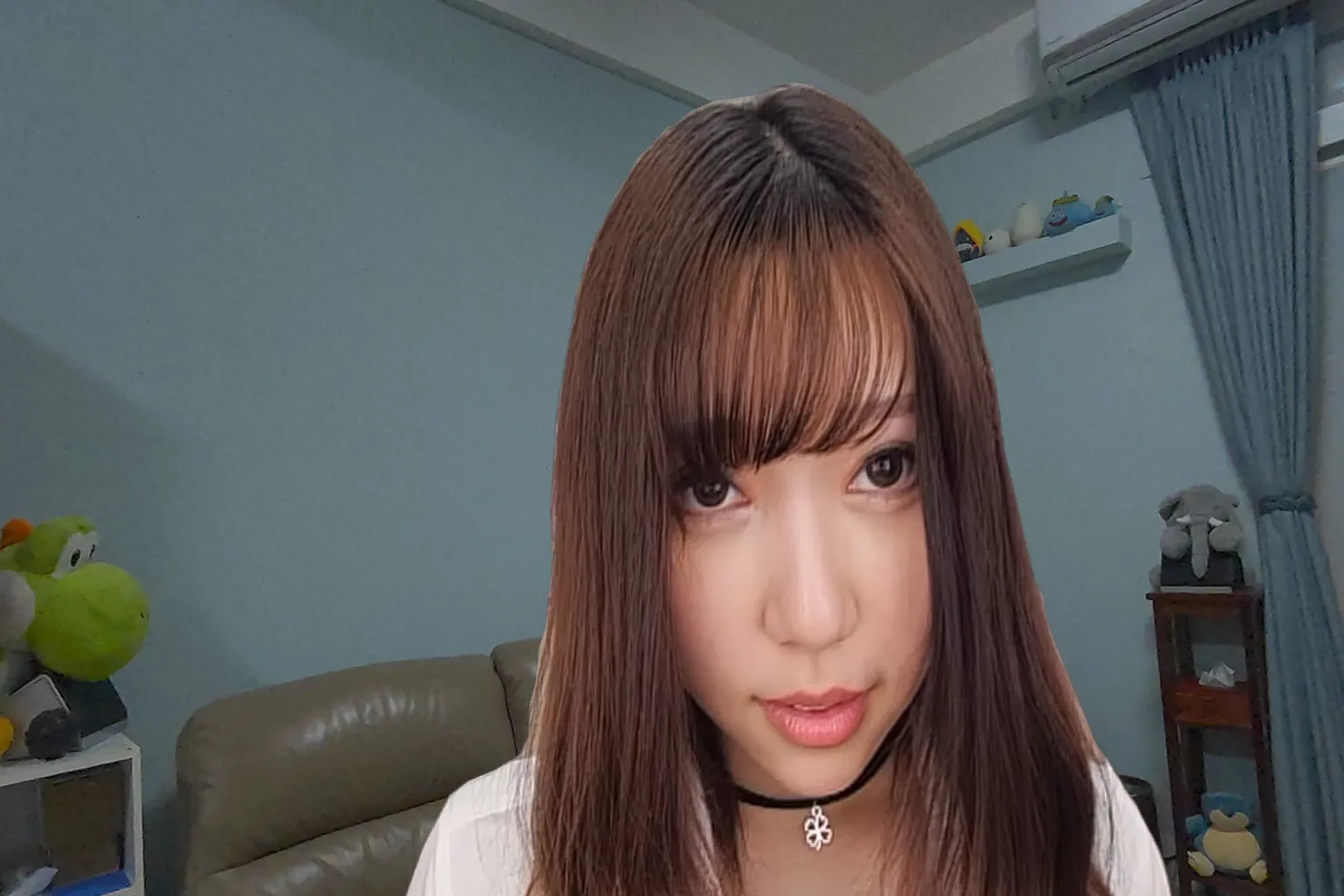 長髪の女の子が黒いチョーカーを身につけ、正面からカメラを見つめており、落ち着いた雰囲気と迫力を感じさせる表情