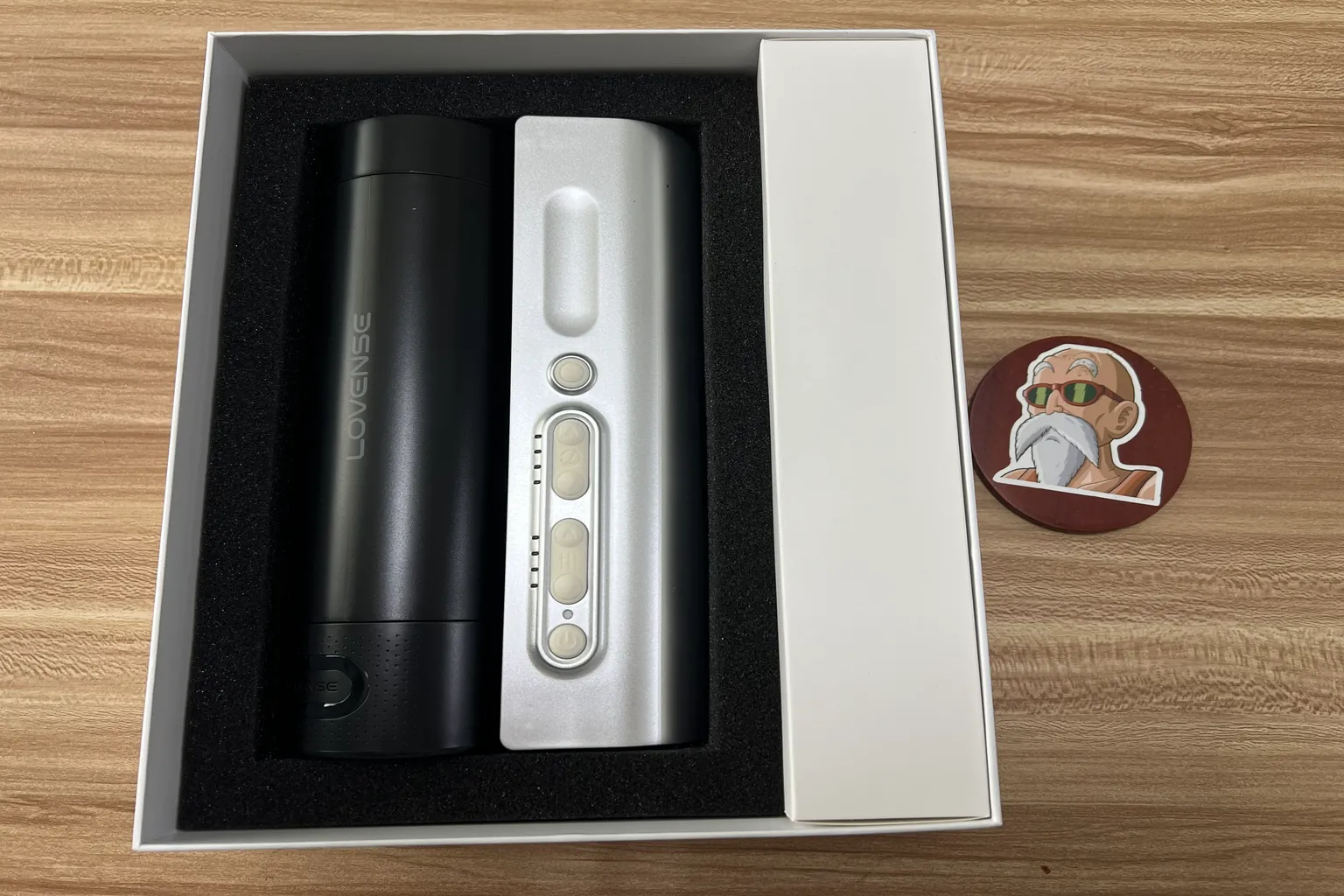 Lovense Solace Proの開封写真。本体が黒い保護フォームに収められ、右側に付属品の箱がある