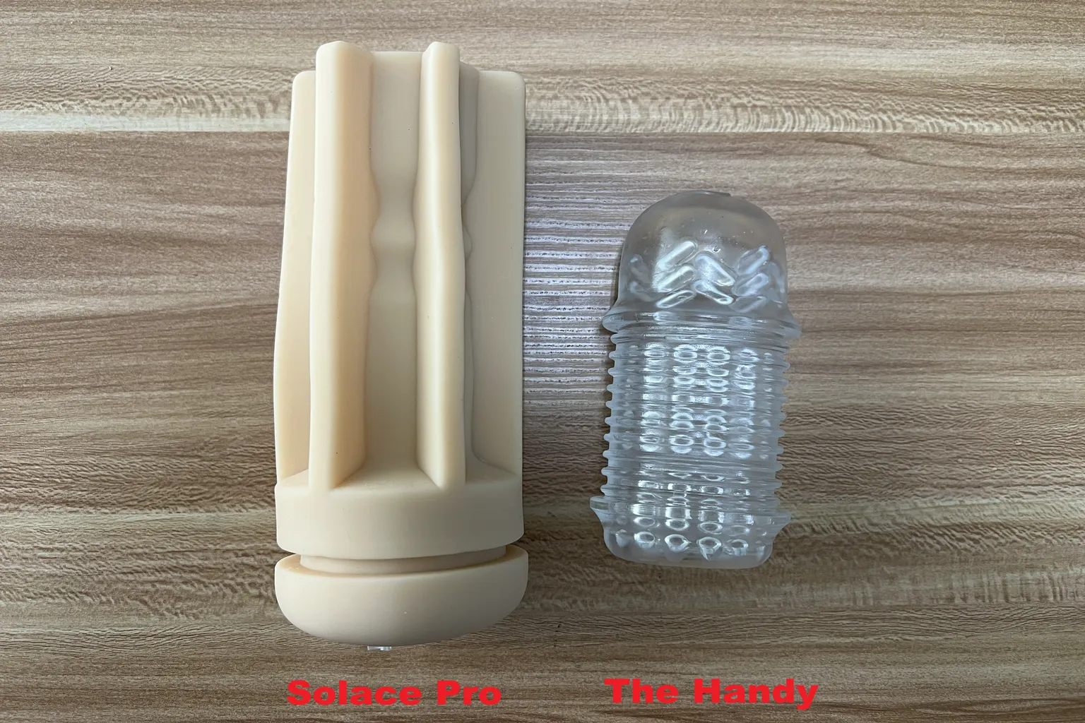 Lovense Solace Proのベージュ色のTPEスリーブと、The Handyの透明なスリーブを並べて、長さや大きさの違いを比較