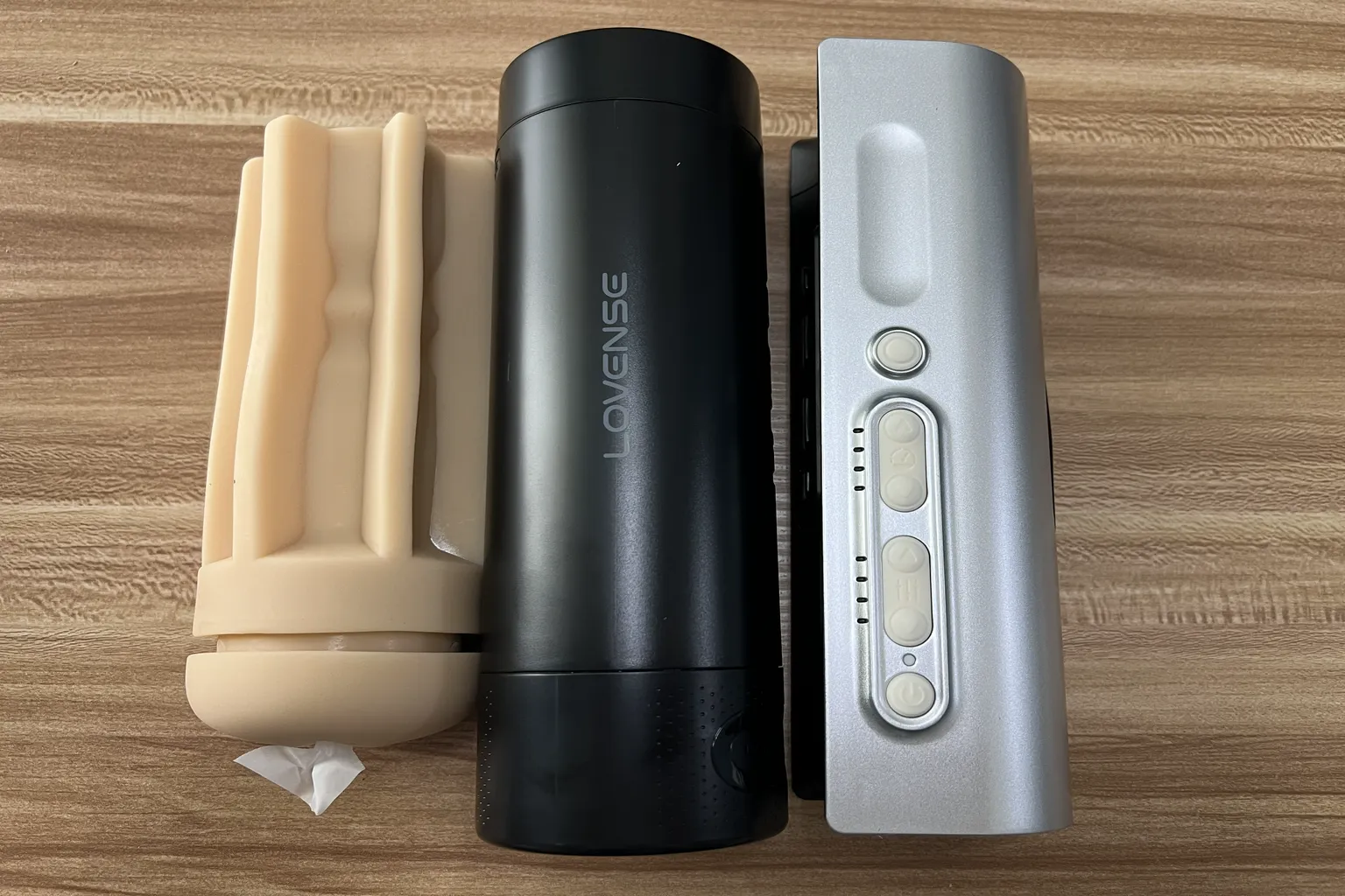 Lovense Solace Proの分解写真。左から取り外し可能なTPEスリーブ、黒いカップケース、シルバーの本体を並べて比較